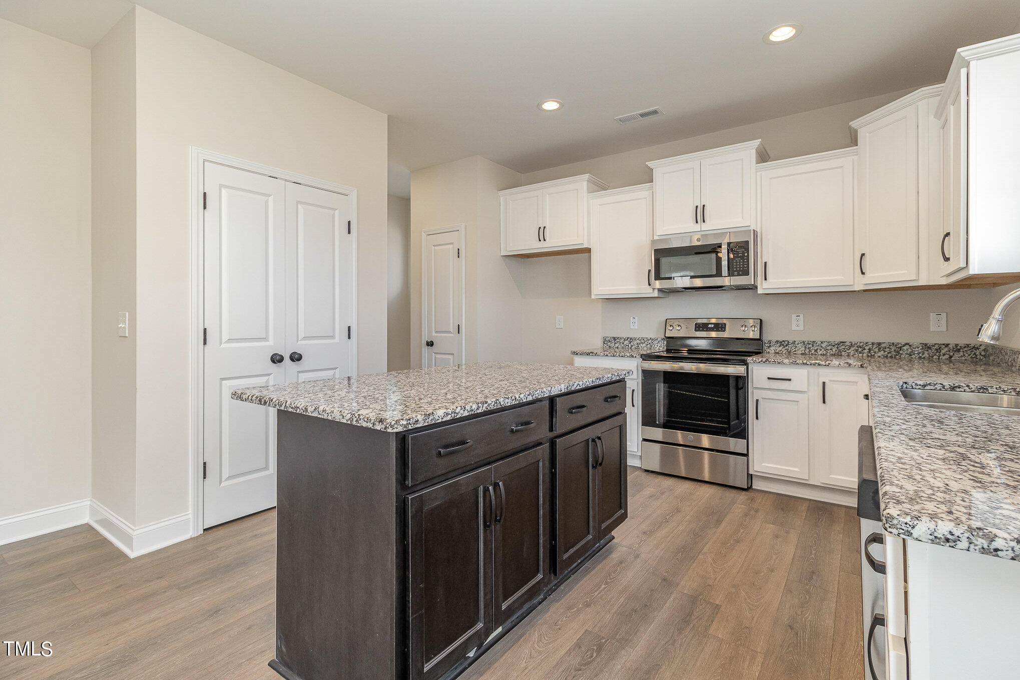 299 Jackson Pond Drive Smithfield, NC 27577 - Photo 15 of 25 a kitchen with stainless steel appliances granite countertop a stove top oven a sink dishwasher and a refrigerator with wooden floor