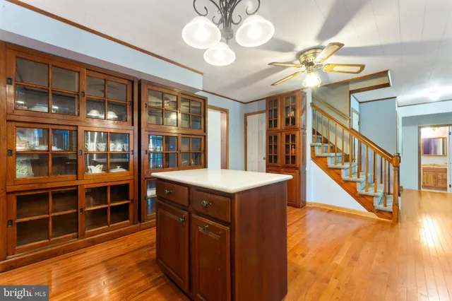 a kitchen with stainless steel appliances granite countertop a refrigerator a sink dishwasher a stove and a dining table with wooden floor