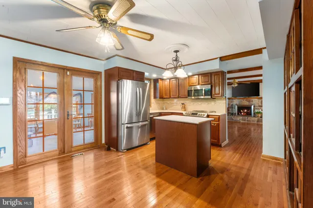 a kitchen with stainless steel appliances granite countertop a sink a stove cabinets counter space and a window