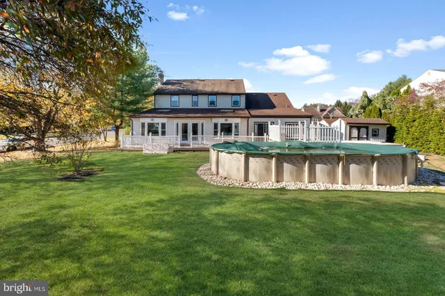 a front view of a house with a garden and trees