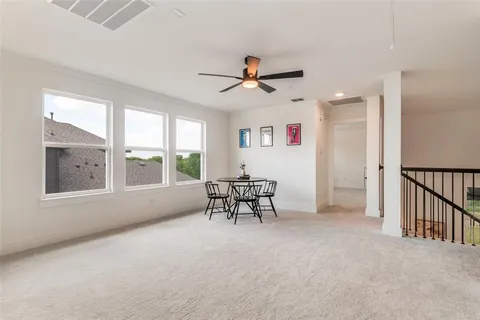 an empty room with furniture fan and windows