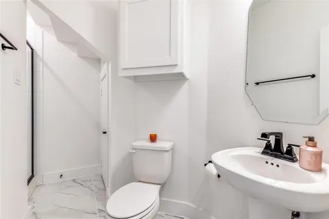 a bathroom with a sink a toilet and a mirror