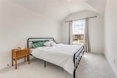 a bed sitting in a bedroom next to a window