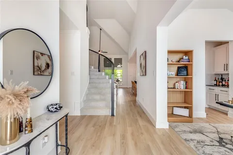 a view of a hallway with wooden floor and entryway