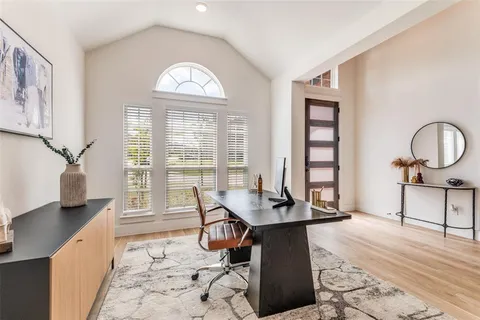 a dining room with wooden floor and a floor to ceiling window