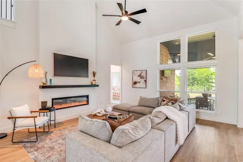 a living room with furniture a flat screen tv and a large window
