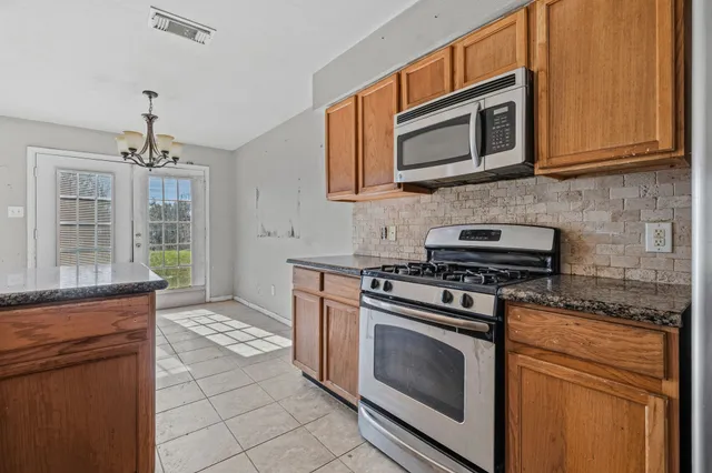 a kitchen with stainless steel appliances granite countertop a stove microwave and cabinets