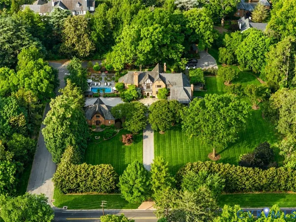 an aerial view of residential house with outdoor space and trees all around