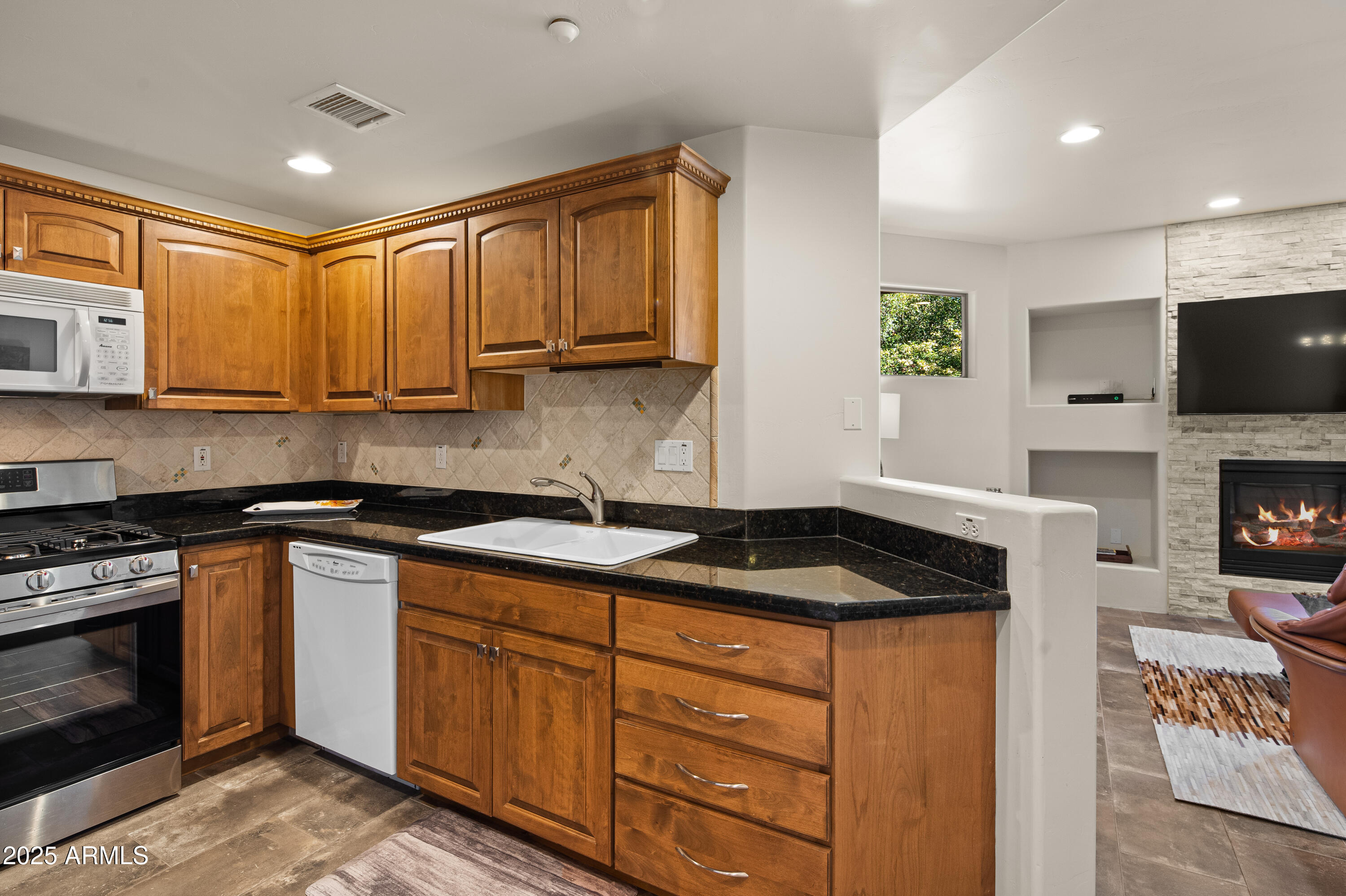 520 Jordan Road, Unit 2 Sedona, AZ 86336 - Photo 10 of 34 a kitchen with granite countertop a stove a sink and a microwave