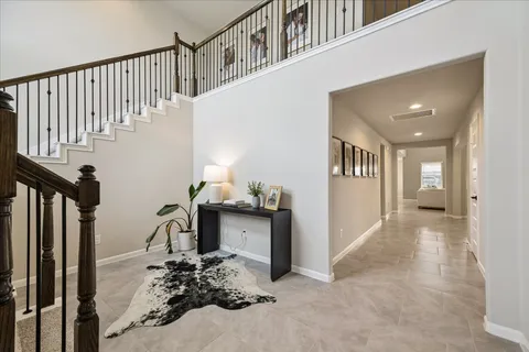 a living room with furniture a flat screen tv and a chandelier