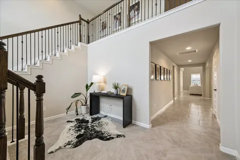 a living room with couches a flat screen tv and kitchen view