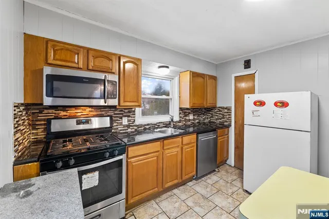 a kitchen with stainless steel appliances a stove a microwave and a refrigerator