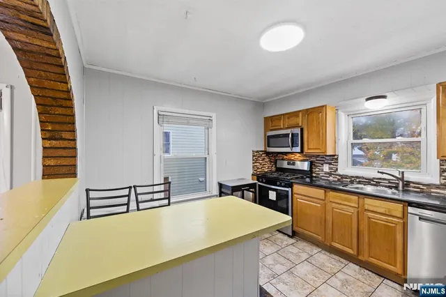 a kitchen with a sink a stove and chairs