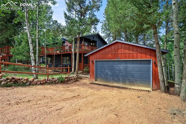 a view of wooden house with a yard and large trees