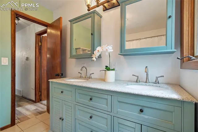 a bathroom with a granite countertop sink and a mirror