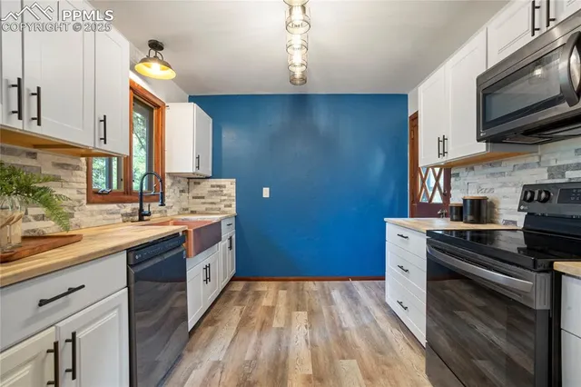 a kitchen with stainless steel appliances a sink stove and cabinets