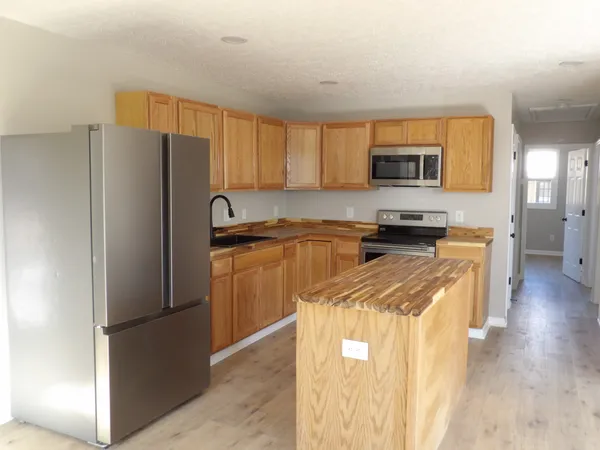 an empty room with ceiling fan and window