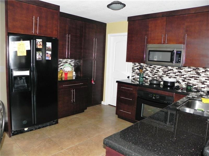 9650 Colorado Court Boca Raton, FL 33434 - Photo 4 of 14 a kitchen with stainless steel appliances kitchen island granite countertop a refrigerator and a stove top oven