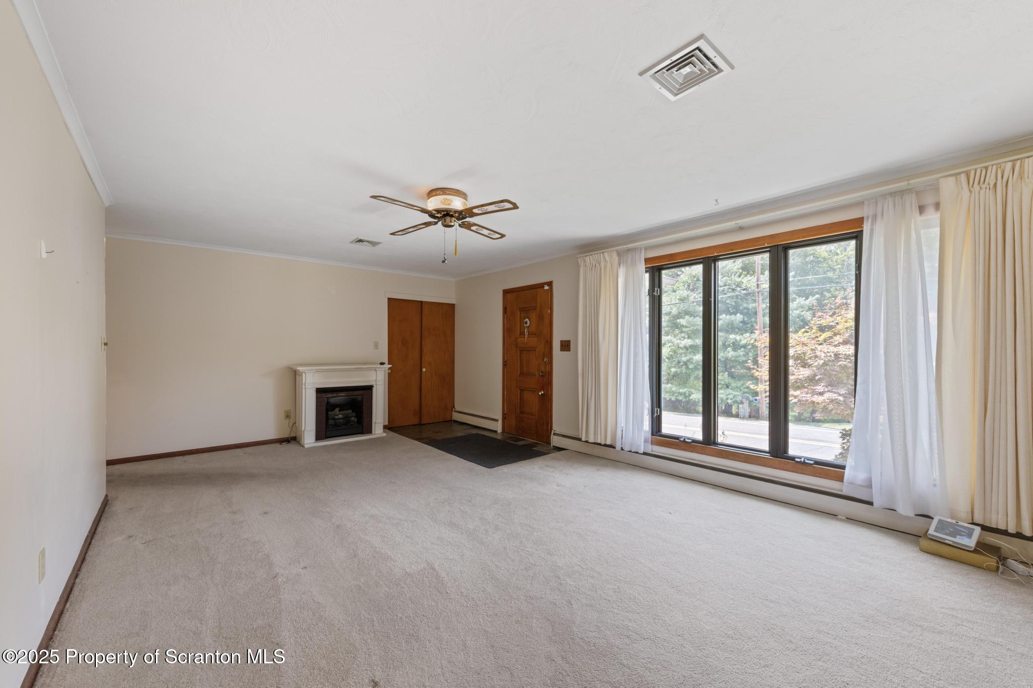 378 Gravel Pond Road Clarks Summit, PA 18411 - Photo 11 of 30 a view of an empty room with a fireplace and a window