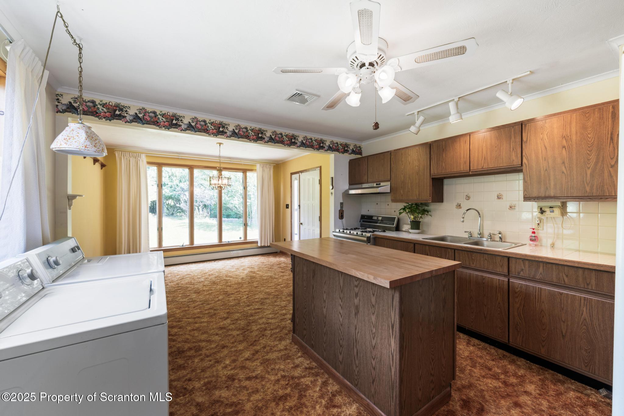 378 Gravel Pond Road Clarks Summit, PA 18411 - Photo 15 of 30 a large kitchen with kitchen island a sink stainless steel appliances and a window