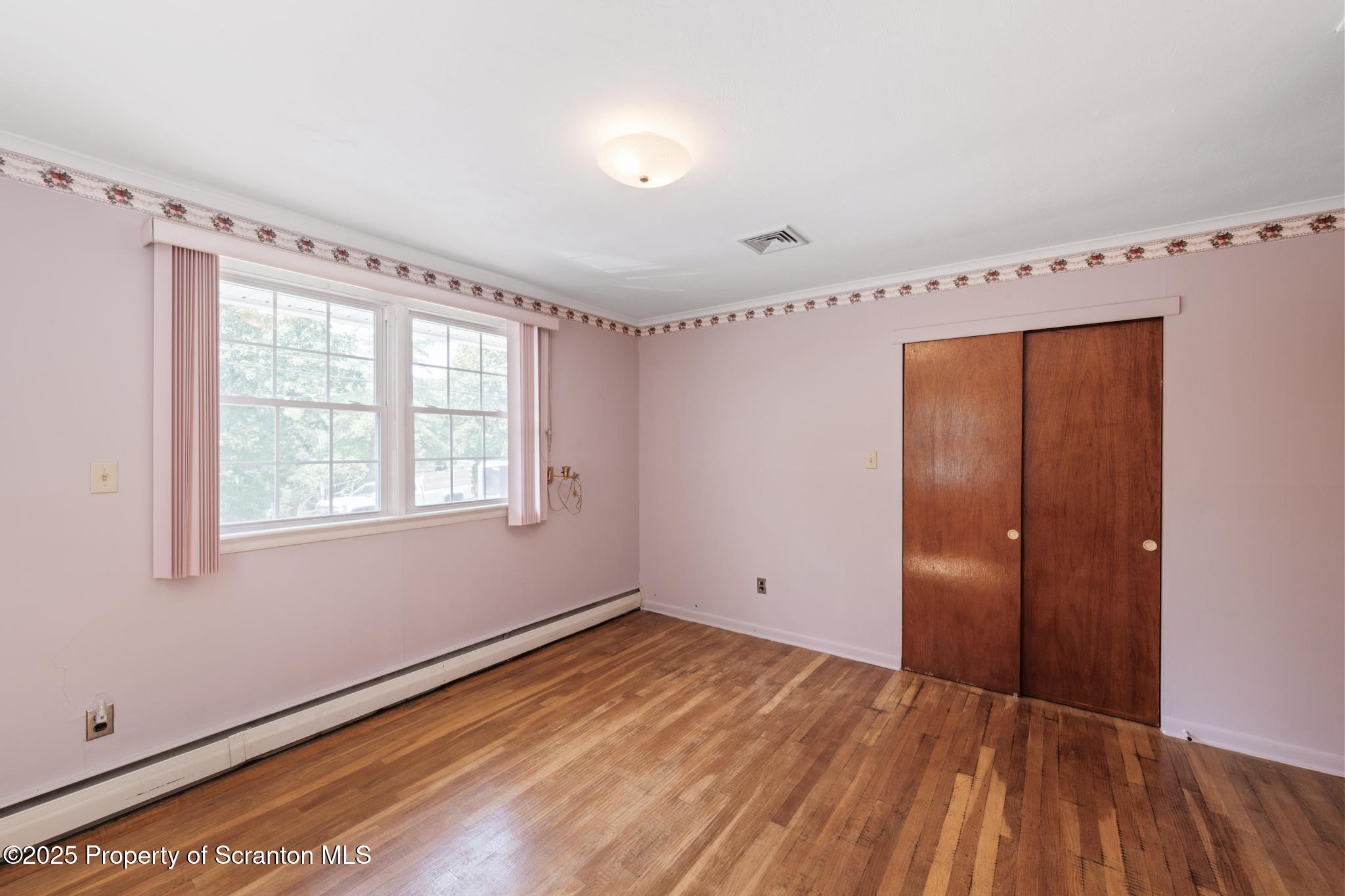 378 Gravel Pond Road Clarks Summit, PA 18411 - Photo 22 of 30 a view of an empty room with wooden floor and a window