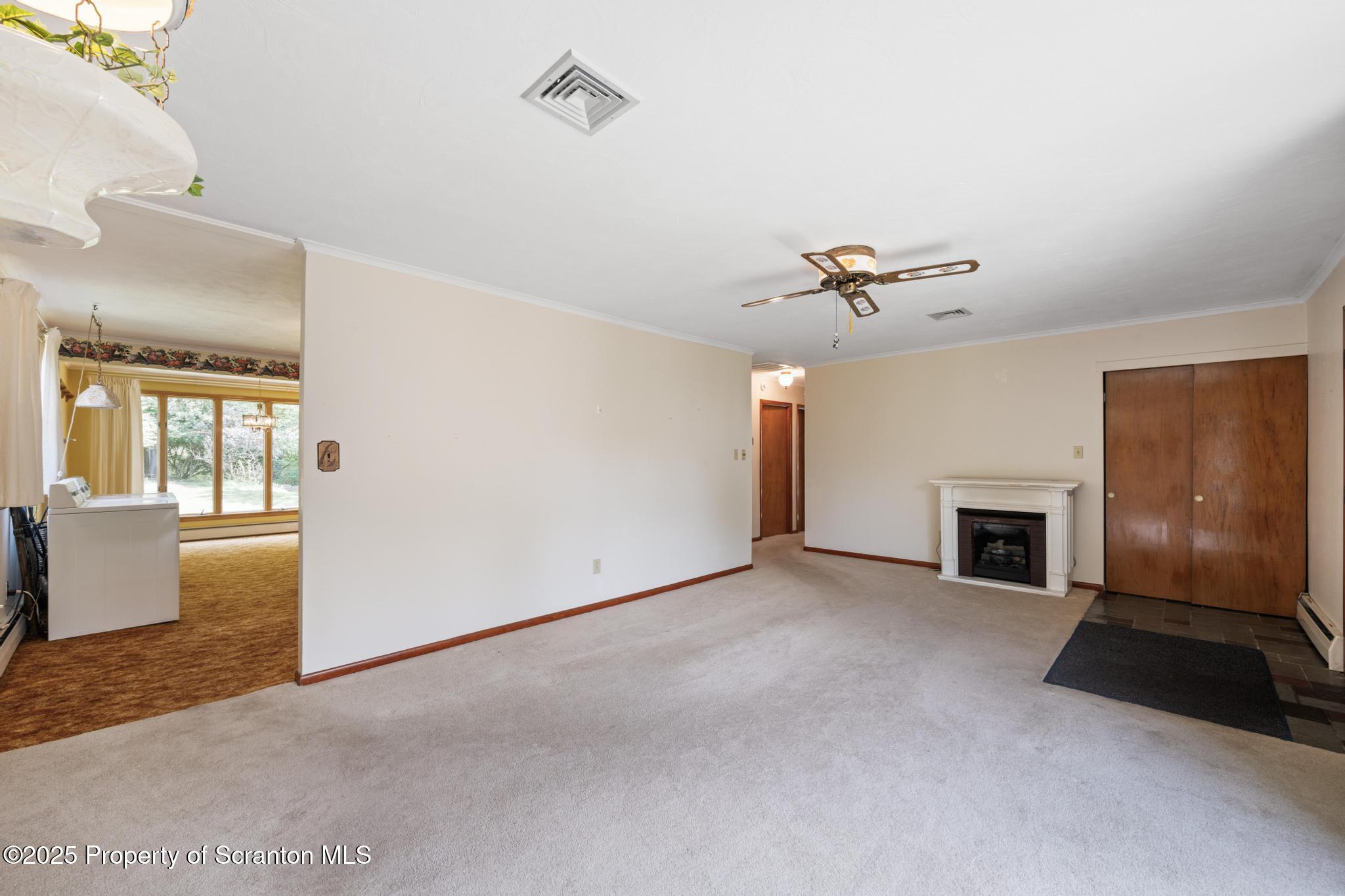 378 Gravel Pond Road Clarks Summit, PA 18411 - Photo 10 of 30 a view of a livingroom with a fireplace a ceiling fan and windows