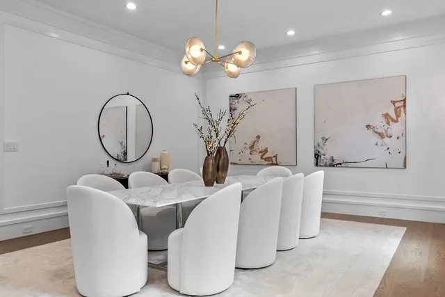 a living room with couches and kitchen view with wooden floor