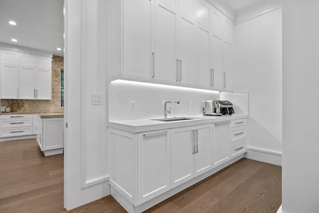 a kitchen with white cabinets and sink
