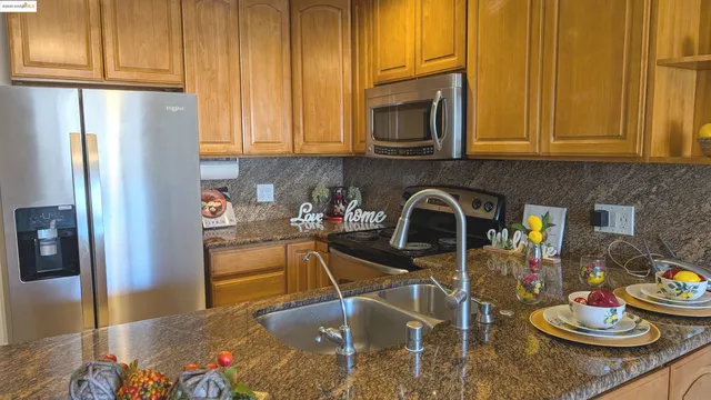 a kitchen with a refrigerator and stove top oven