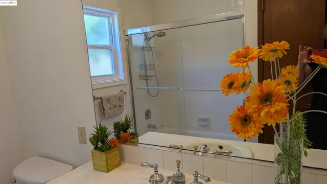 a bathroom with a sink a toilet and a mirror