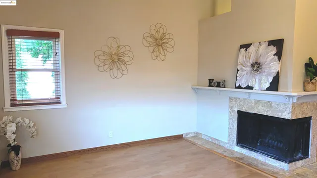 an empty room with windows and fireplace