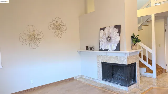 a living room with a fireplace and a wall painting