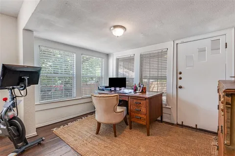 a view of a workspace with furniture and a window