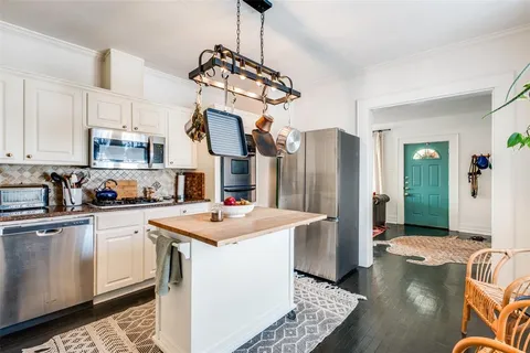 a kitchen with stainless steel appliances granite countertop a sink a stove a refrigerator and cabinets