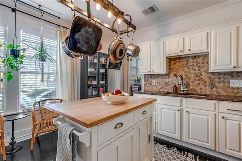 a kitchen with white cabinets and chandelier