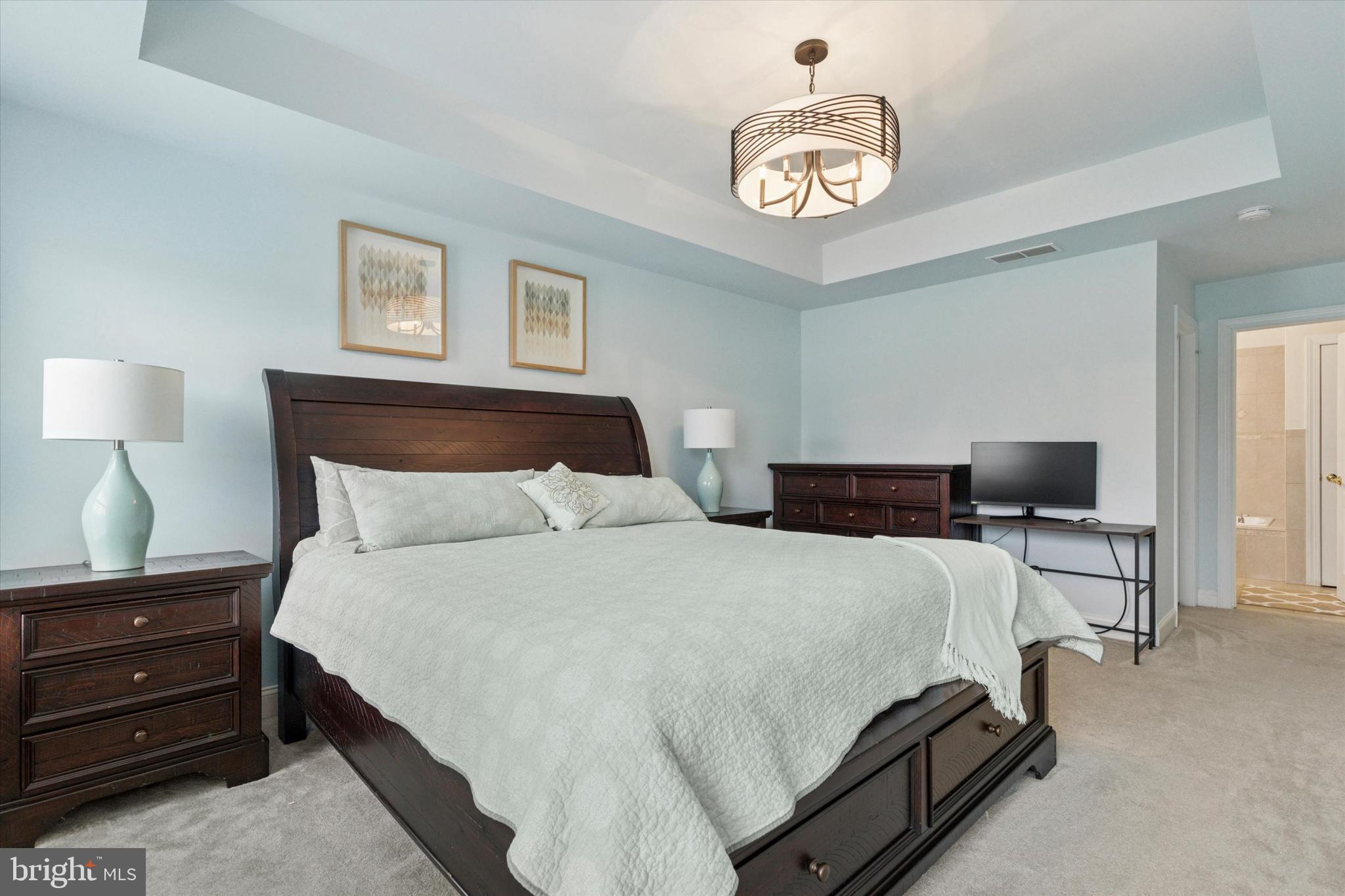 3229 Meadow View Circle, Unit 157 Furlong, PA 18925 - Photo 22 of 28 a bedroom with a bed and a chandelier