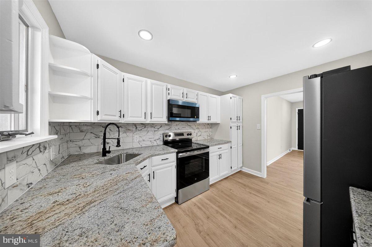24 Vansant Road Newark, DE 19711 - Photo 13 of 44 a kitchen with granite countertop a refrigerator stove and sink