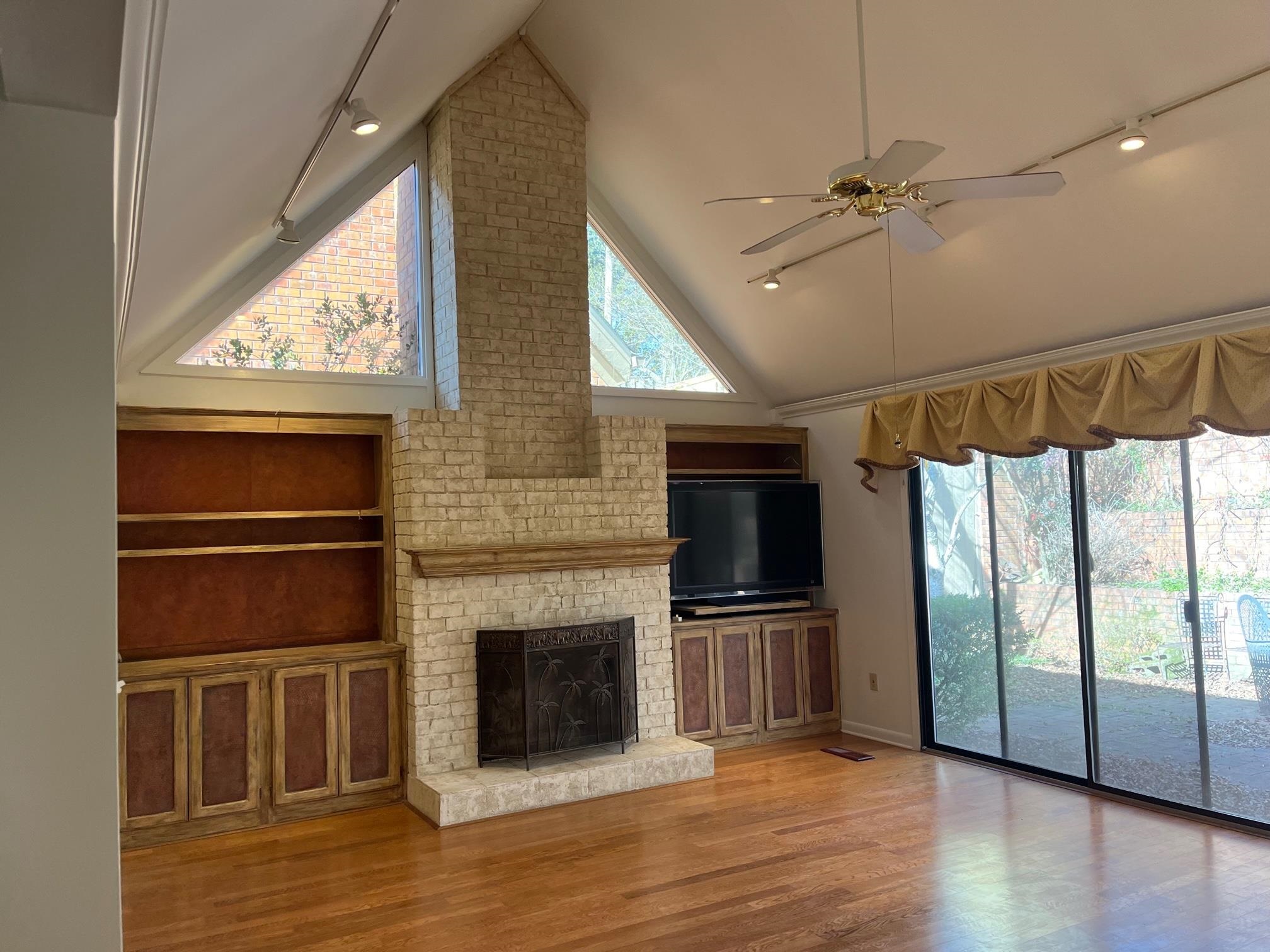 6536 Cherryhill Ridge Memphis, TN 38120 - Photo 3 of 8 a view of a livingroom with wooden floor a ceiling fan a fireplace and windows