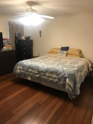 a bedroom with a bed and wooden floor