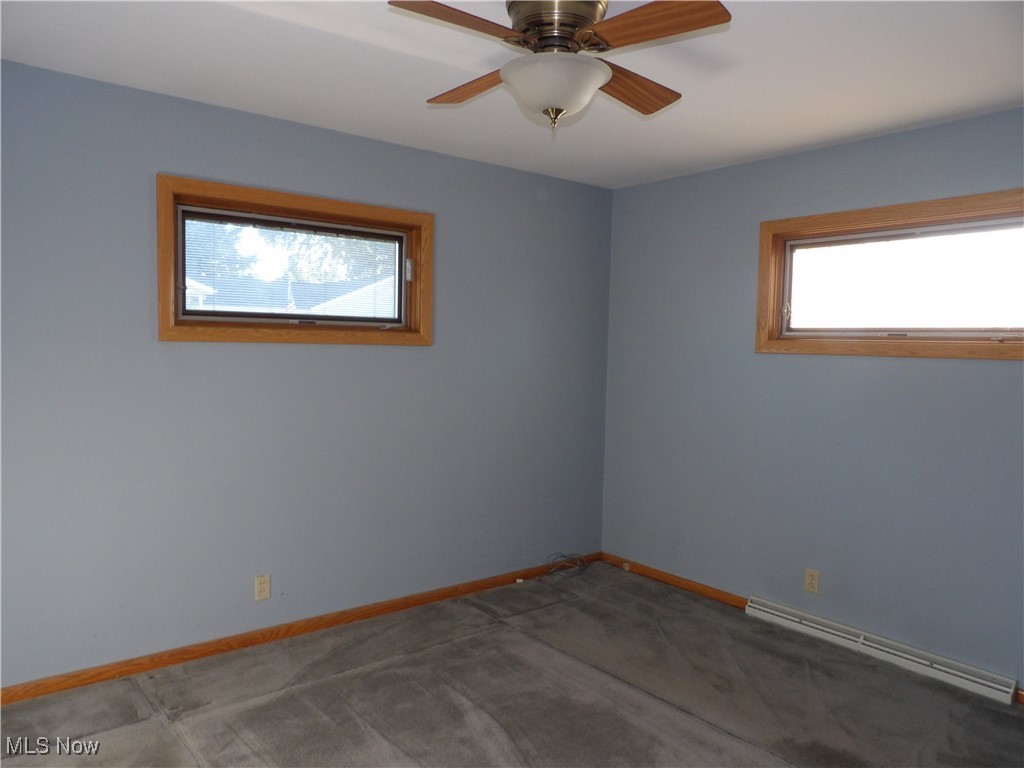 515 Hillman Road Akron, OH 44312 - Photo 14 of 17 Unfurnished room with a baseboard radiator, carpet floors, and a ceiling fan