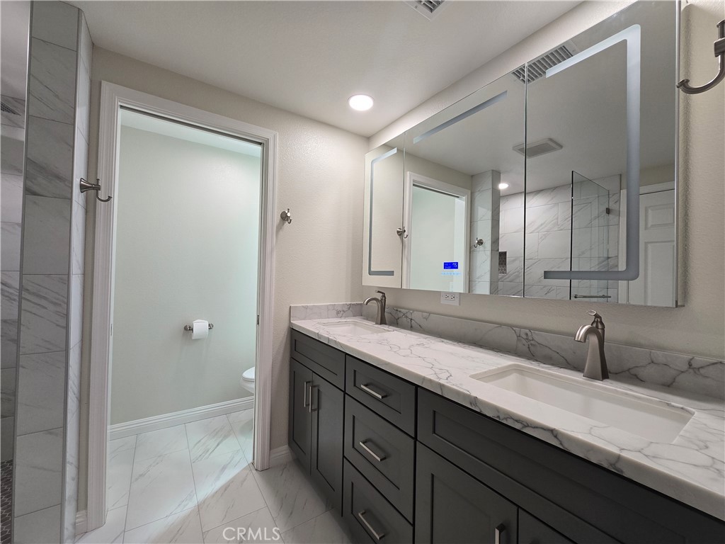 6846 Barkwood Road Riverside, CA 92506 - Photo 12 of 27 a bathroom with a granite countertop sink and a mirror