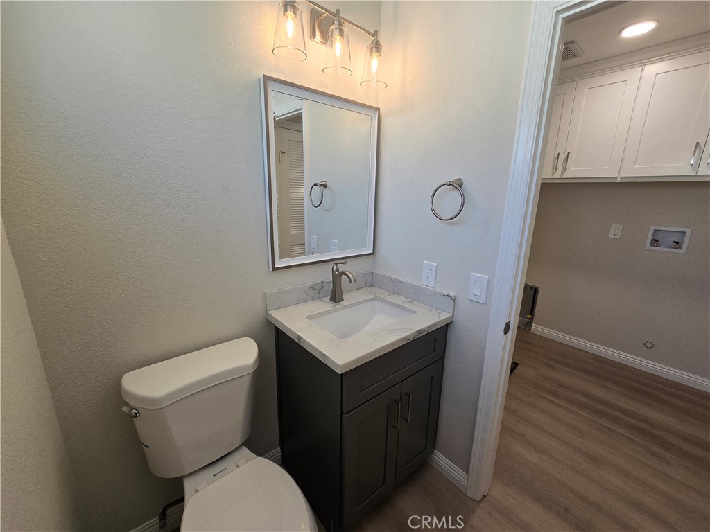 6846 Barkwood Road Riverside, CA 92506 - Photo 16 of 27 a bathroom with a granite countertop toilet sink and mirror
