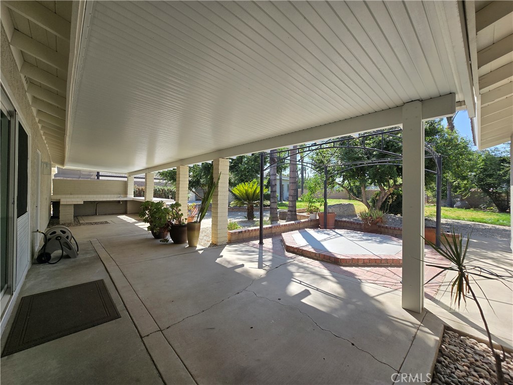 6846 Barkwood Road Riverside, CA 92506 - Photo 24 of 27 a view of a patio with table and chairs potted plants with floor to ceiling window