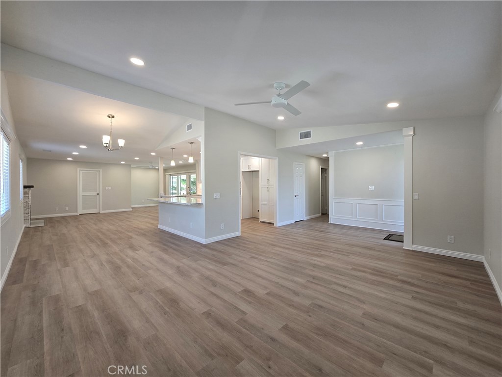6846 Barkwood Road Riverside, CA 92506 - Photo 5 of 27 a view of an empty room with wooden floor and a kitchen