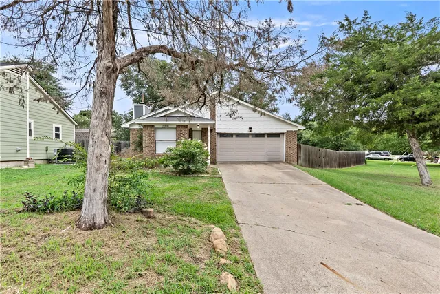 a front view of a house with a yard and an trees