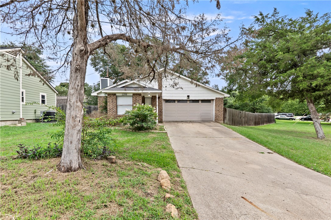 2208 Lobo Drive Bryan, TX 77807 - Photo 1 of 23 a front view of a house with a yard and an trees