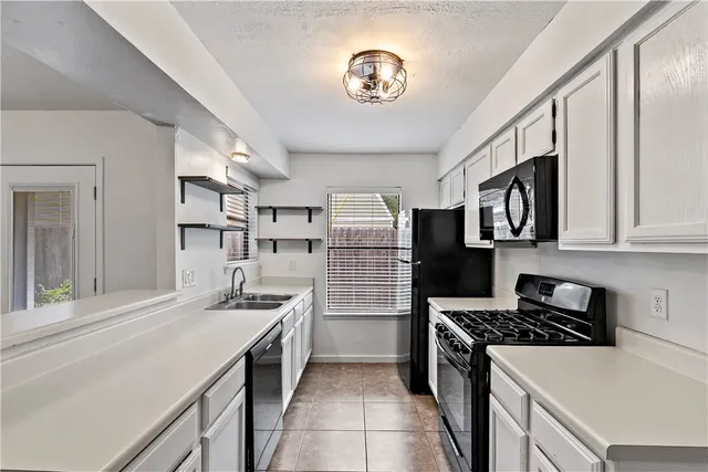 a kitchen with stainless steel appliances granite countertop a stove and a refrigerator