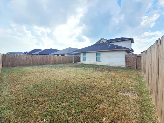 a view of a house with a yard and a large tree