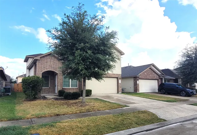a front view of a house with garden and garage