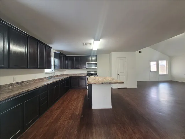 a kitchen with counter top space and wooden floor